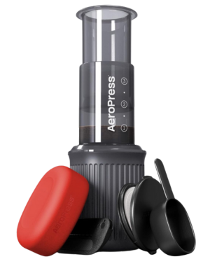AeroPress coffee maker set with accessories, featuring a transparent, marked chamber and a gray ribbed base.