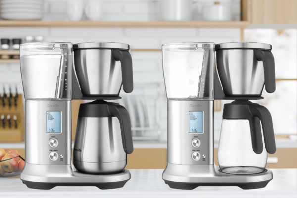 Breville Precision Brewer coffee machines in a sleek, minimalist kitchen with fresh apples on the countertop.