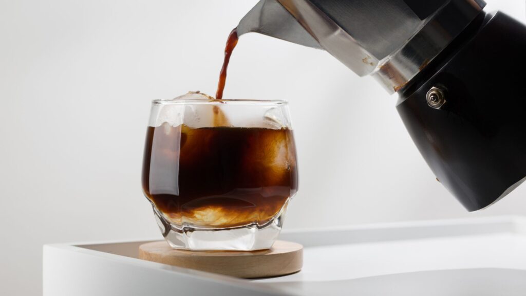 Espresso vs Americano showdown featuring iced coffee being prepared using a traditional stovetop moka pot.