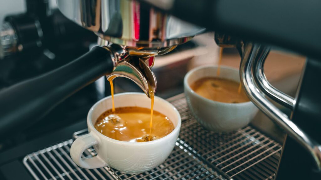 Lungo vs Espresso showdown featuring dual spouts effortlessly brewing into white ceramic cups.