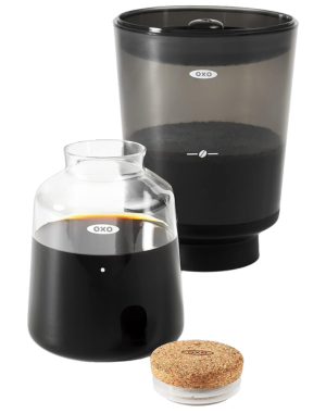 OXO Brew cold brew coffee maker with clear glass carafe, smoky brewing container, and a cork stopper.