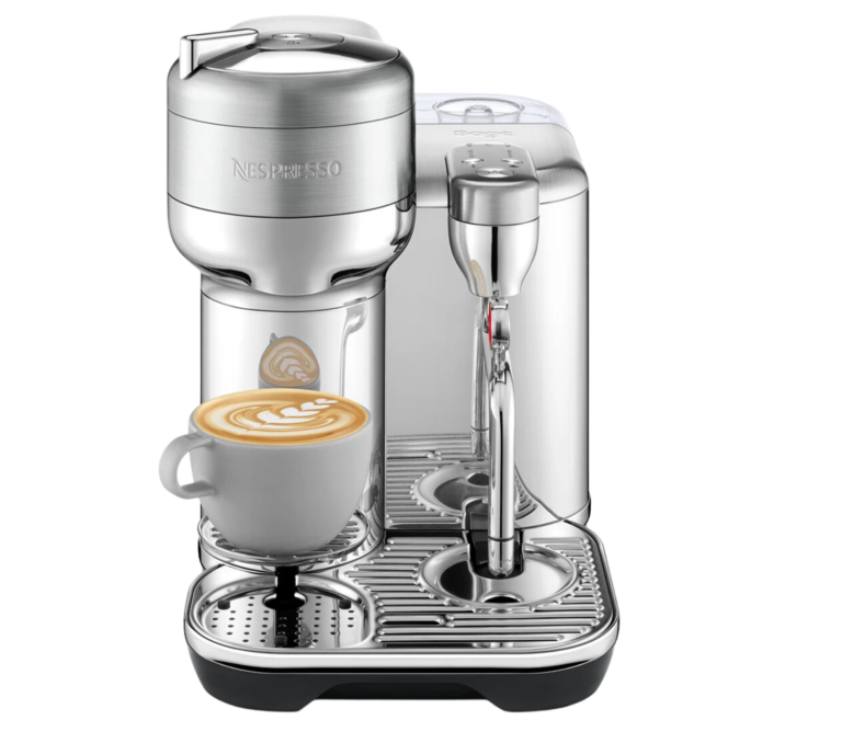 Vertuo Creatista sleek coffee machine with filled cappuccino cup, metallic nozzle and transparent reservoir.